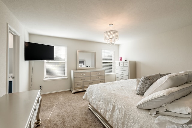 bedroom with light colored carpet, an inviting chandelier, and a textured ceiling