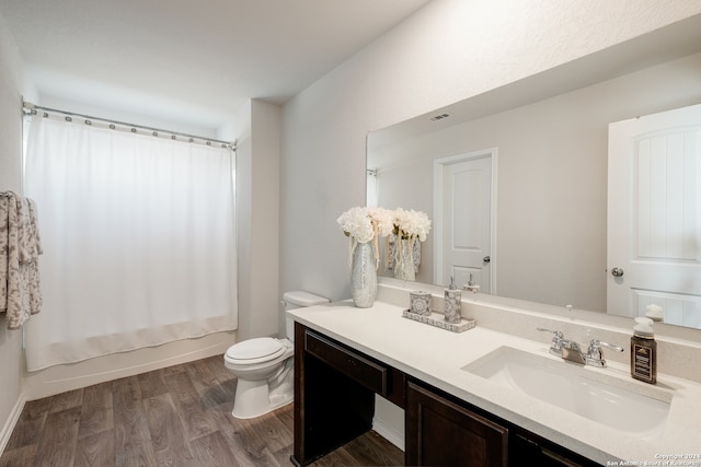 full bathroom featuring vanity, hardwood / wood-style flooring, toilet, and shower / bath combo