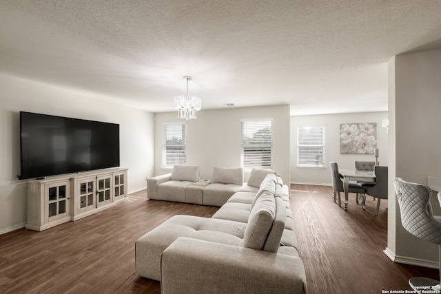 living room featuring a notable chandelier, hardwood / wood-style flooring, and a textured ceiling