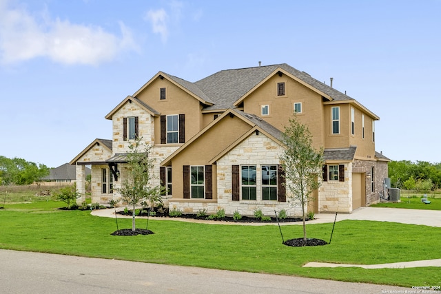 craftsman inspired home with a garage, a front yard, and central AC