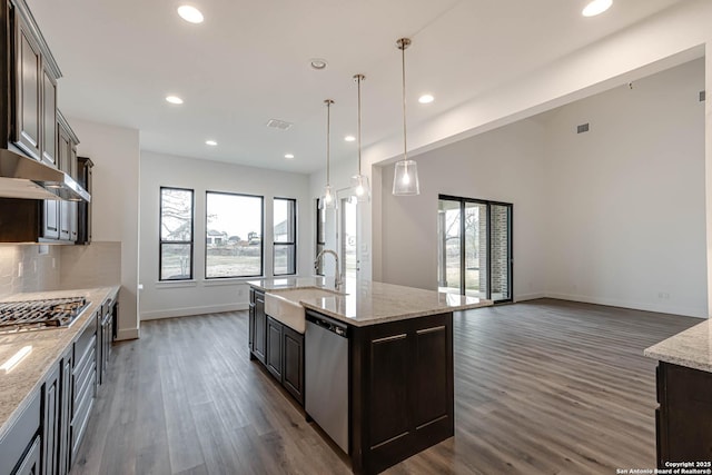 kitchen with dark brown cabinetry, an island with sink, and appliances with stainless steel finishes