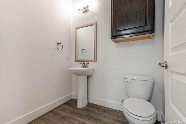 bathroom featuring wood-type flooring and toilet