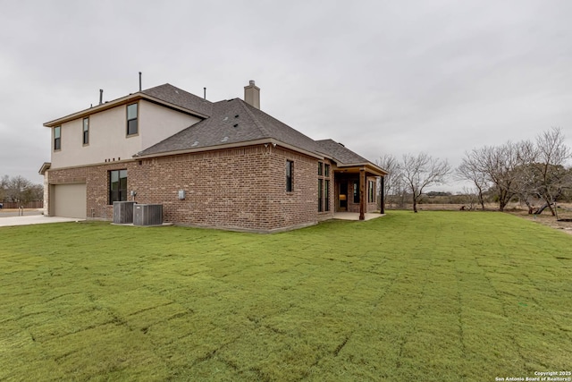 view of side of home with a yard, a garage, and central AC