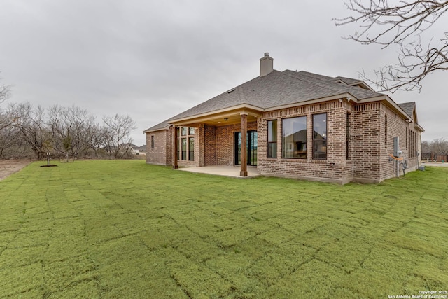 rear view of house with a patio area and a lawn