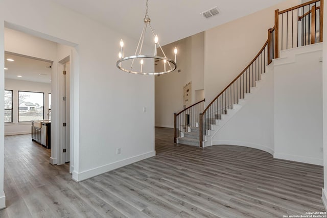 unfurnished dining area featuring hardwood / wood-style flooring and a notable chandelier