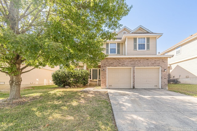 view of front of home with a garage, cooling unit, and a front lawn