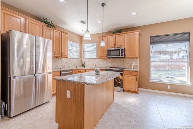 kitchen featuring decorative backsplash, a kitchen island, decorative light fixtures, light stone counters, and stainless steel appliances