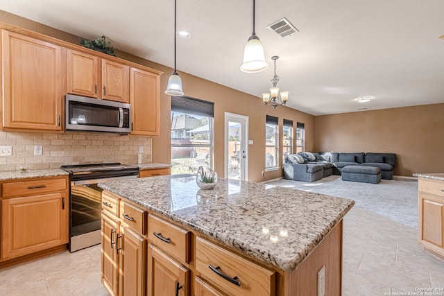 kitchen with tasteful backsplash, decorative light fixtures, a chandelier, appliances with stainless steel finishes, and a center island