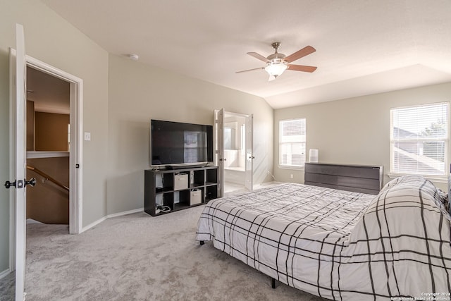 bedroom featuring ceiling fan, light colored carpet, connected bathroom, and vaulted ceiling