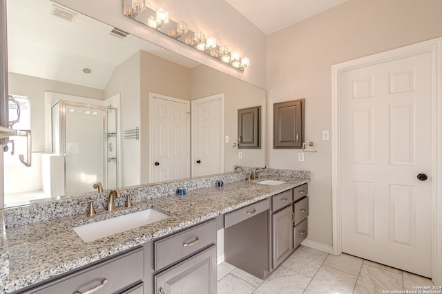 bathroom with vanity, vaulted ceiling, and a shower with door