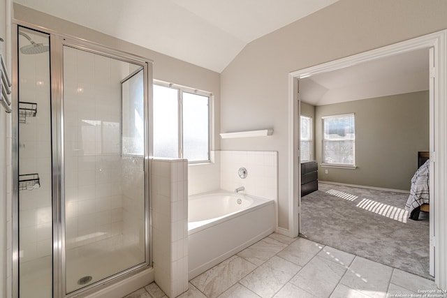 bathroom with a healthy amount of sunlight, vaulted ceiling, and plus walk in shower