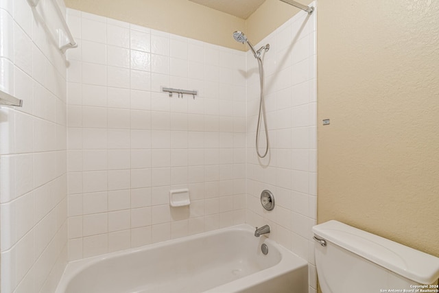 bathroom featuring tiled shower / bath and toilet