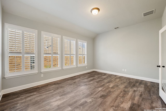 spare room with vaulted ceiling and dark hardwood / wood-style floors