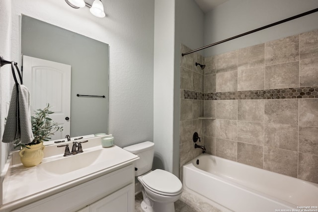 full bathroom featuring tiled shower / bath, vanity, and toilet