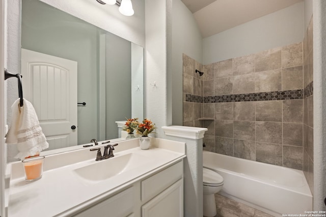 full bathroom featuring tiled shower / bath combo, vanity, and toilet