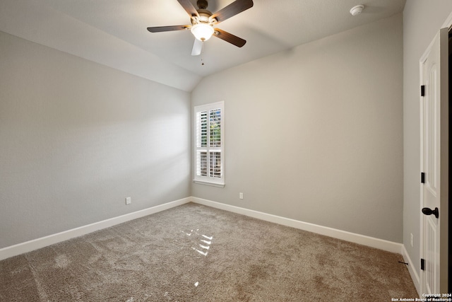 carpeted spare room featuring ceiling fan and vaulted ceiling