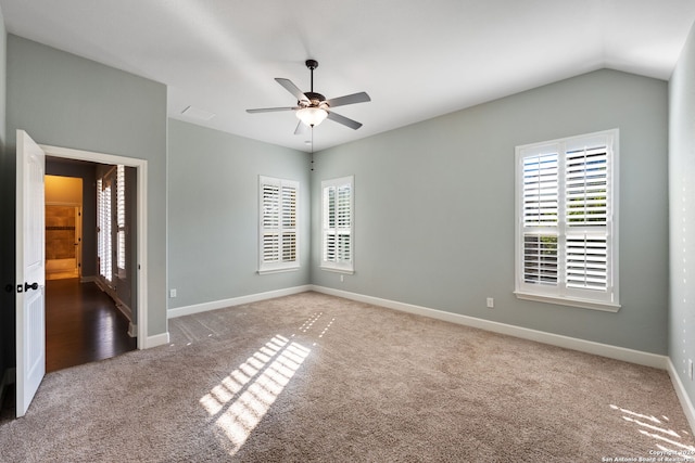 carpeted empty room featuring vaulted ceiling and ceiling fan