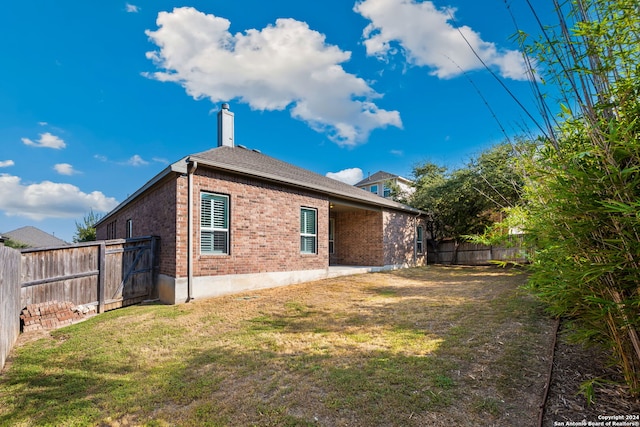 back of property featuring a lawn