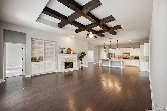 unfurnished living room featuring beamed ceiling, ceiling fan, coffered ceiling, dark wood-type flooring, and a fireplace