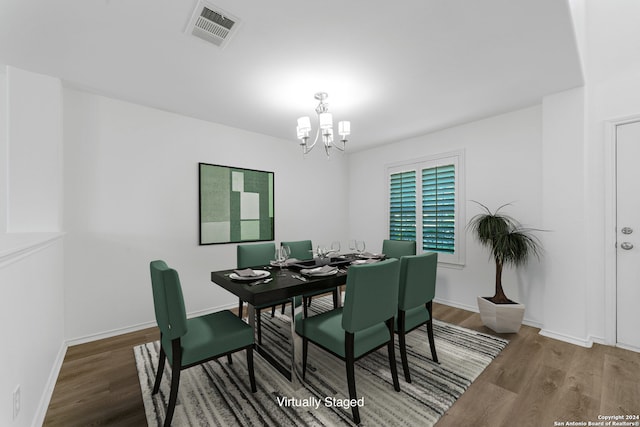 dining area with wood-type flooring and a chandelier