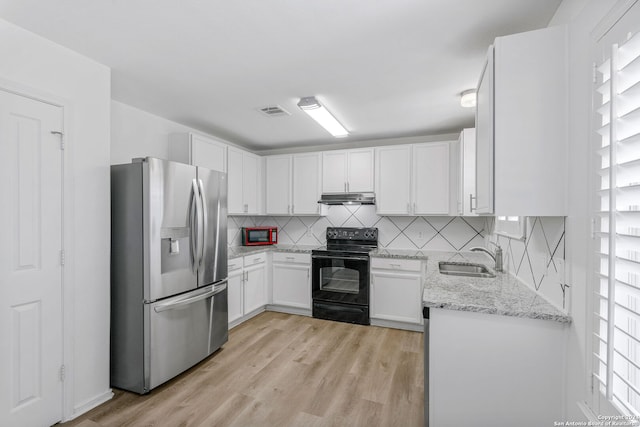 kitchen featuring stainless steel fridge, light hardwood / wood-style flooring, light stone counters, black range with electric cooktop, and white cabinets