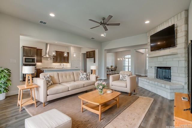 5014 Estates Oak Way, San Antonio, TX 78263 - living room with dark wood-style flooring, ceiling fan, a chandelier, recessed lighting, and a fireplace