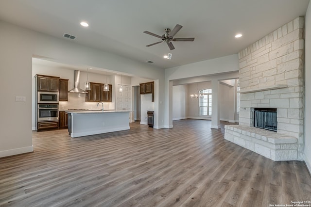 5014 Estates Oak Way, San Antonio, TX 78263 - unfurnished living room with a sink, wood finished floors, baseboards, a chandelier, and a ceiling fan