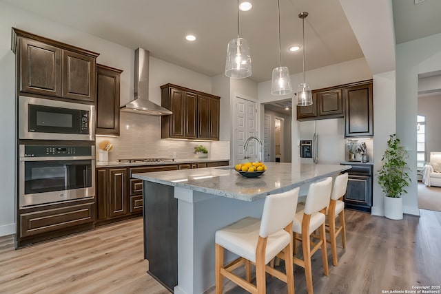 5014 Estates Oak Way, San Antonio, TX 78263 - kitchen with appliances with stainless steel finishes, wall chimney exhaust hood, a sink, dark brown cabinets, and recessed lighting