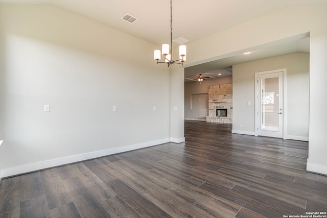 unfurnished living room with dark wood-type flooring, lofted ceiling, a fireplace, and ceiling fan with notable chandelier