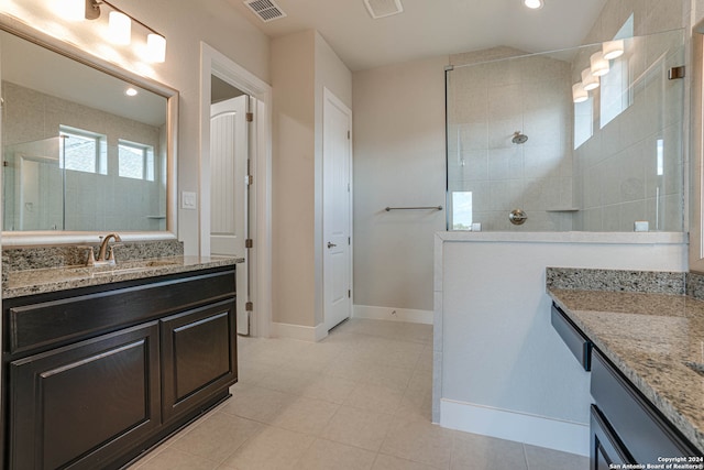 bathroom with a tile shower and vanity