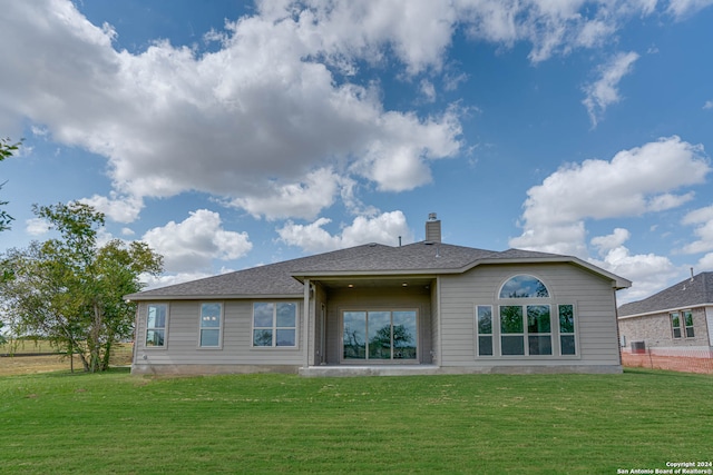 rear view of property with a yard