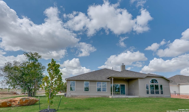 back of house featuring a patio area and a lawn