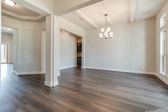 spare room featuring a notable chandelier, beamed ceiling, and dark hardwood / wood-style flooring