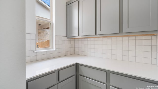 kitchen with tasteful backsplash and gray cabinets