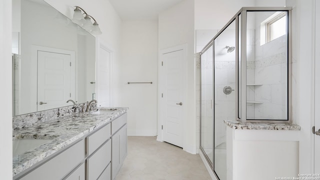 bathroom featuring a shower with shower door, vanity, and tile patterned floors