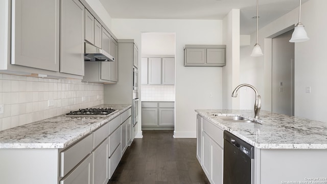 kitchen featuring stainless steel gas stovetop, dark hardwood / wood-style floors, dishwasher, pendant lighting, and sink