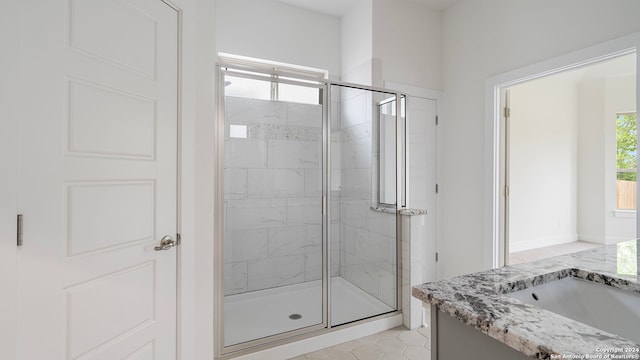 bathroom with a healthy amount of sunlight, walk in shower, and vanity