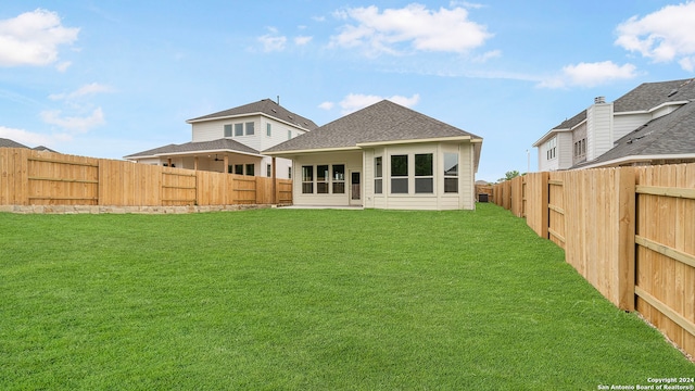 rear view of property featuring a lawn