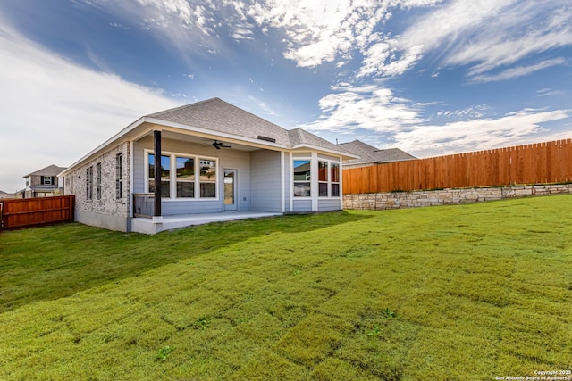 back of property featuring ceiling fan, a patio area, and a lawn