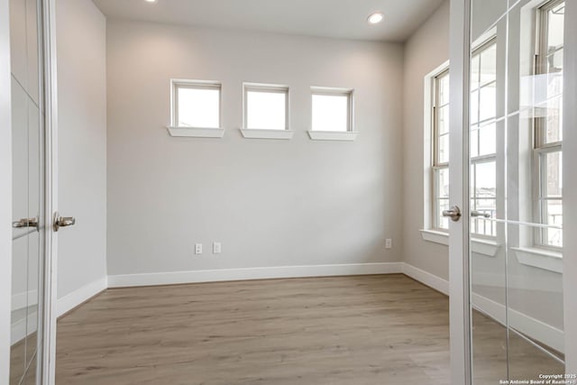 spare room featuring plenty of natural light and light hardwood / wood-style flooring