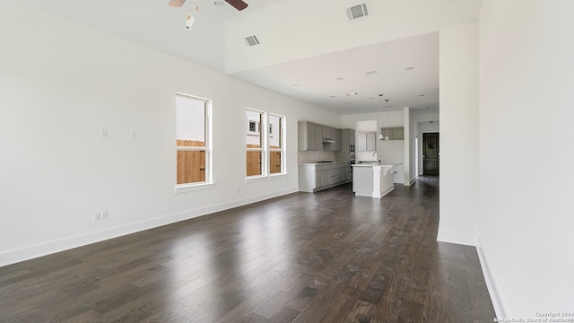 unfurnished living room featuring ceiling fan, lofted ceiling, dark hardwood / wood-style floors, and sink