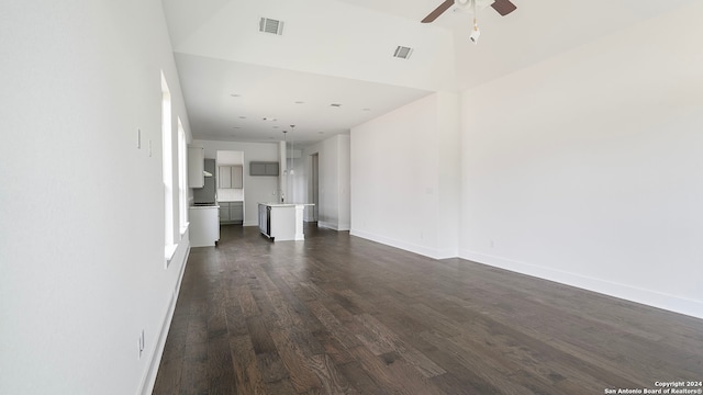 unfurnished living room featuring ceiling fan and dark wood-type flooring