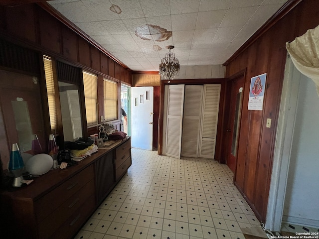 hallway featuring wood walls and ornamental molding