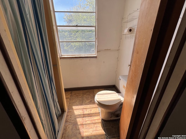 bathroom featuring toilet and a shower with curtain