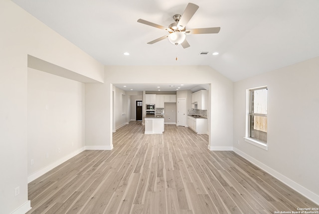 unfurnished living room with light hardwood / wood-style floors, ceiling fan, and vaulted ceiling