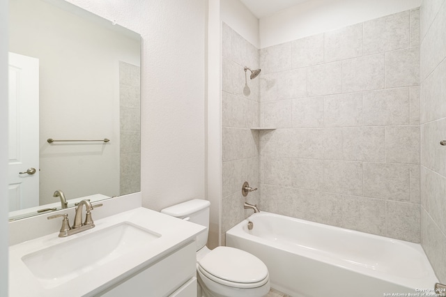 full bathroom featuring toilet, tiled shower / bath, and vanity