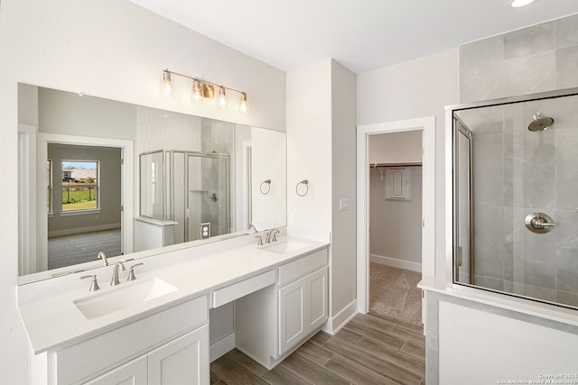 bathroom featuring vanity, an enclosed shower, and wood-type flooring