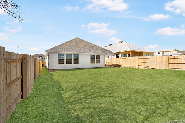 back of house with a lawn