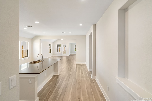 hall with sink and light wood-type flooring