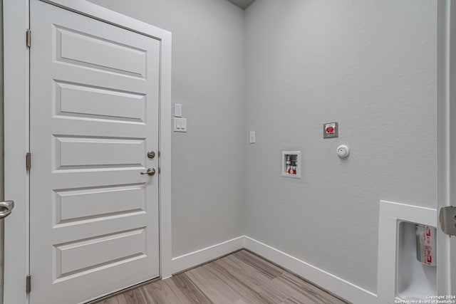 laundry room featuring hookup for an electric dryer, light hardwood / wood-style flooring, hookup for a gas dryer, and washer hookup